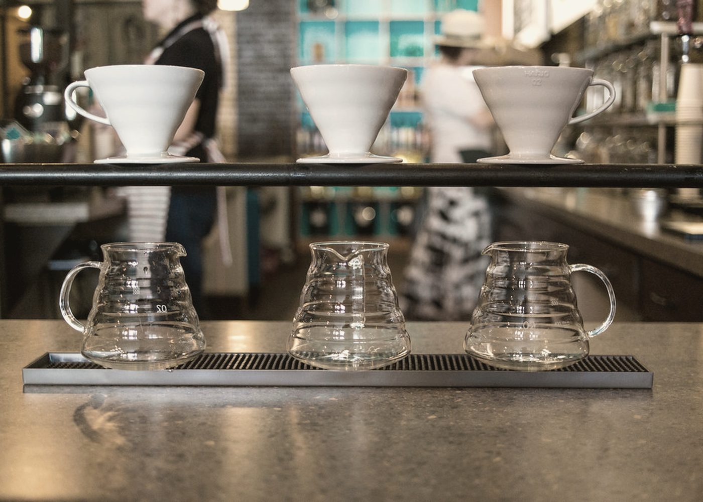 Pour over brewers lined up along the bar.