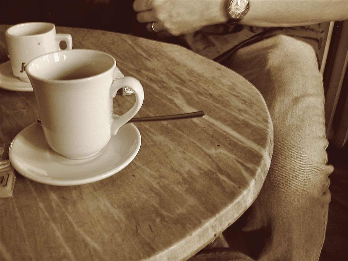 Two espresso cups on a round table by the window.